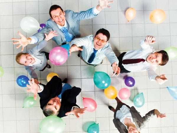 Corporate workers tossing balloons in the air